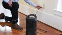 A man plug in a space heater into the wall